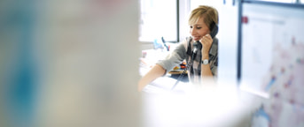 Mitarbeiterin im Büro telefoniert Mitarbeiterin im Büro telefoniert